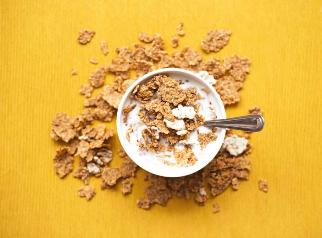 cornflakes banana milk in cereal bowl with spoon