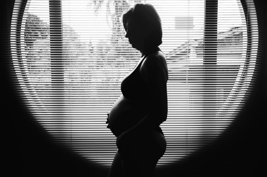 pregnant woman in front of window silhouette 