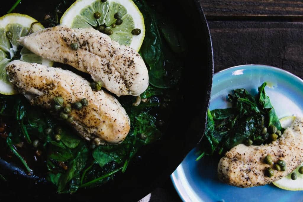 lemon caper chicken and garlic spinach on plate