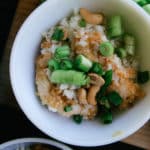 cashew orange chicken cauliflower rice green onions in a bowl