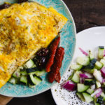 greek omelet on plate with olives and tomatoes