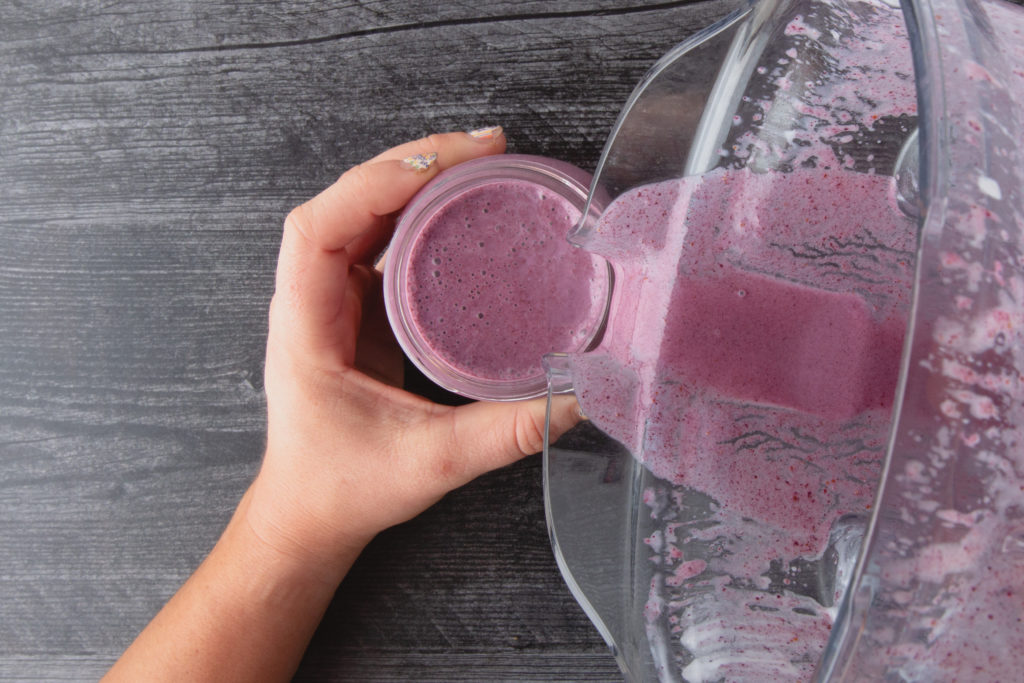 pouring a smoothie into a glass