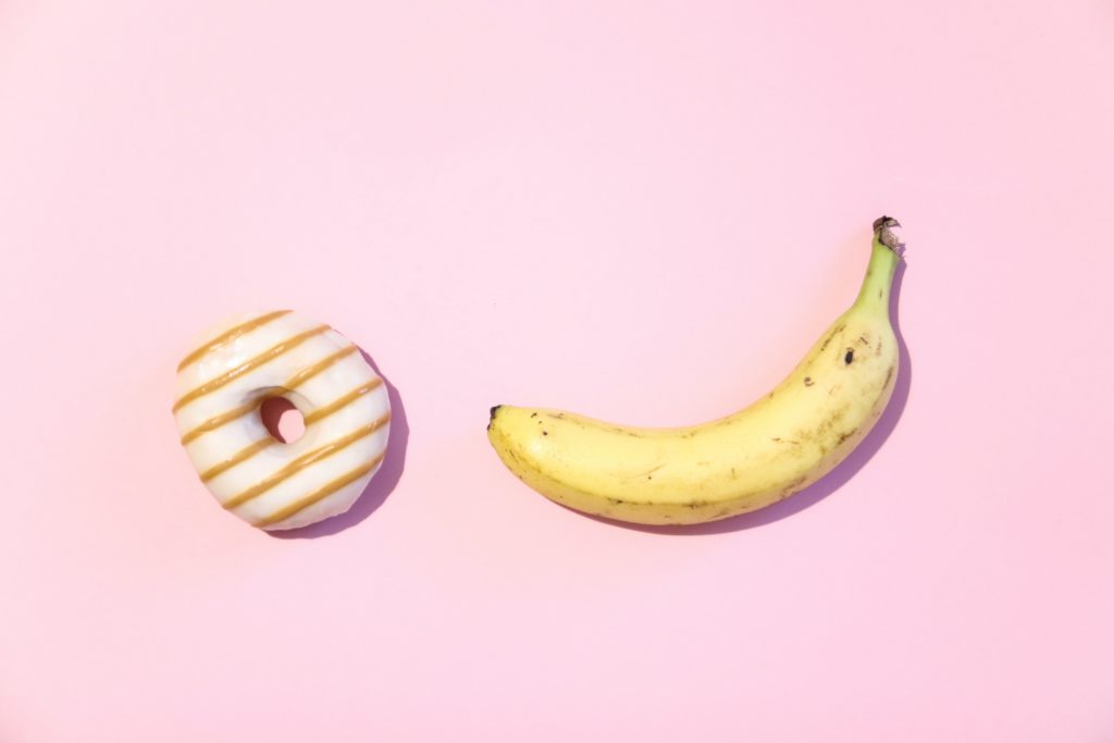 banana and donut on pink background