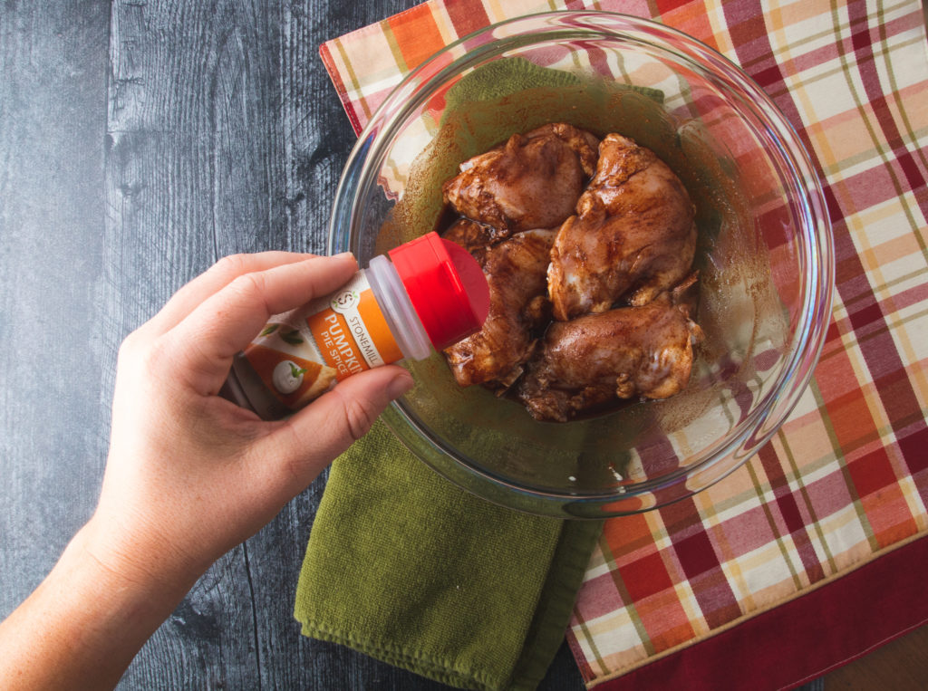 sprinkling chicken thighs with pumpkin spiced seasoning blend