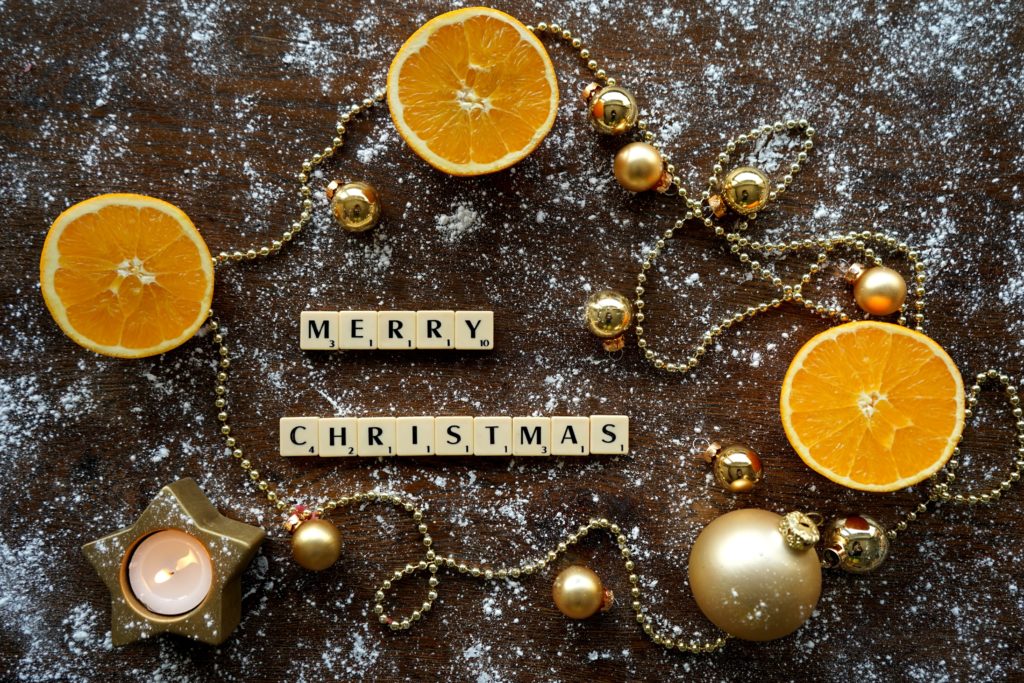 merry christmas tiles with oranges beads and candles