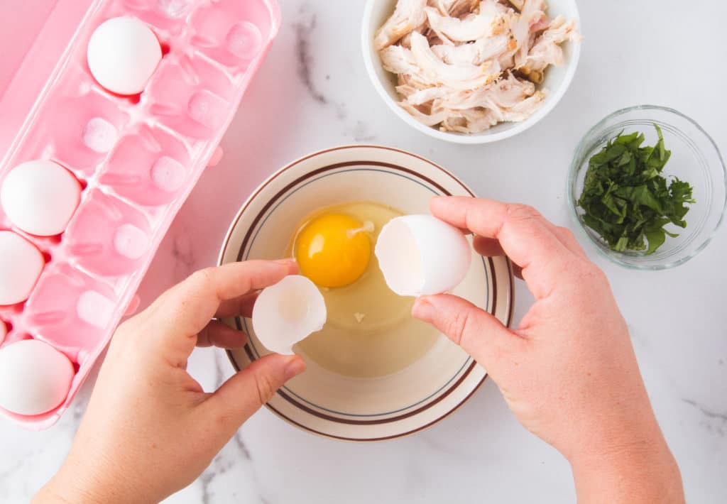 two hands cracking an egg